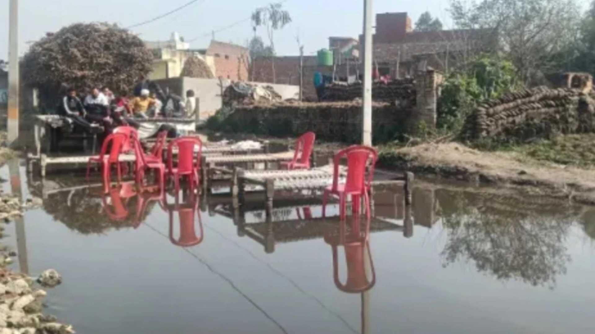 मुजफ्फरनगर: जलभराव से परेशान ग्रामीण पानी में चारपाई बिछाकर धरने पर बैठे
