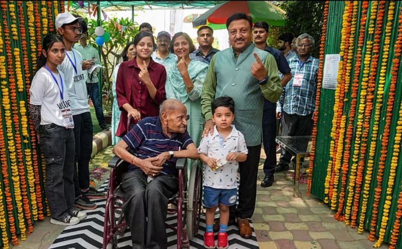 95 वर्षीय पिता को व्हीलचेयर पर लेकर वोट देने पहुंचे मुख्य चुनाव आयुक्त